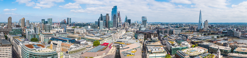 The soaring skyscrapers of the City of London financial district overlooking Tower Bridge across the River Thames to the iconic spire of The Shard in the heart of London, UK.