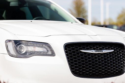 Joliet, IL, USA - April 28, 2019: The front end of a white 2018 Chrysler 300 with a beautiful bokeh / blurred background.