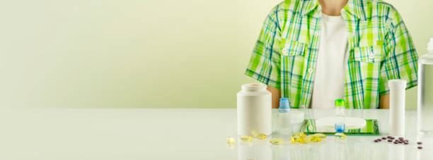 Boy siting at the table with contact lenses, eye drops and copy space