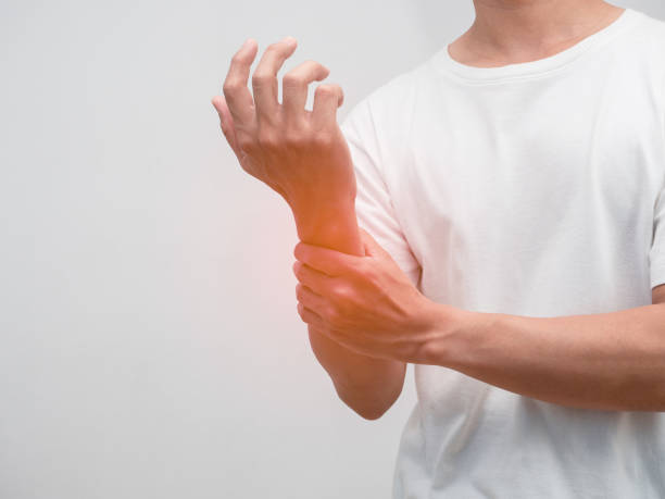istock Close up male hand hurt his wrist studio shot 1452922182