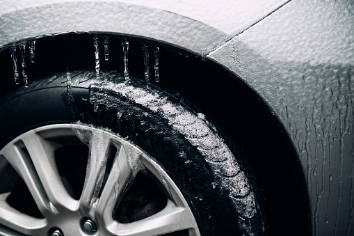 A vehicle coated with a sheet of ice from freezing rain during a winter storm, tiny icicles hanging from the car.   Shot in Washington state, USA.
