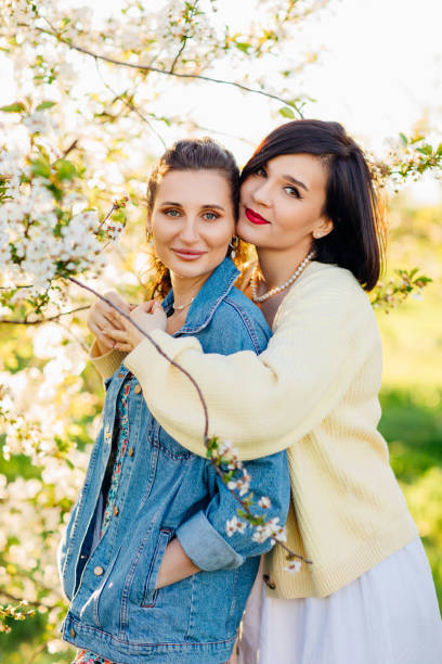 istock two attractive women hugging in a spring garden. 1452922760