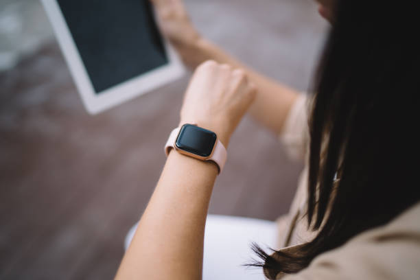 istock Cropped image of millennial female checking received notification on mockup smartwatch with copy space touchscreen for application advertising, selective focus on wearable gadget with blank display 1452923657