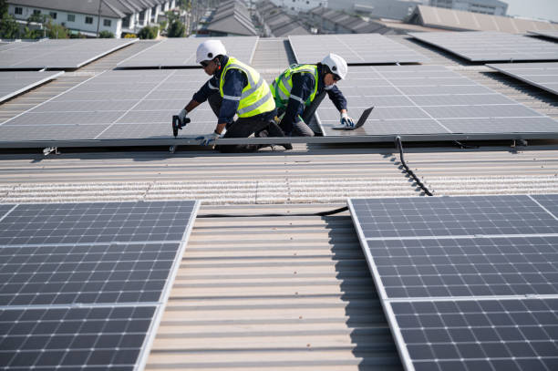 istock Caucasian and African American engineer man use electric screwdriver and computer notebook working with solar panel on roof factory 1452924258