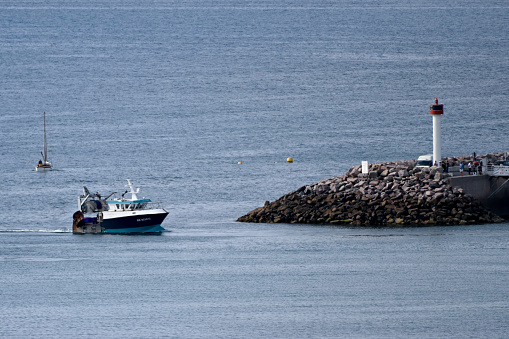 Erquy, France, September 20, 2022 - The shellfish / barge trawler Arco - Iris at the harbor entrance in Erquy