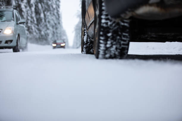 istock Car on a snowy winter road amid forests 1452925631