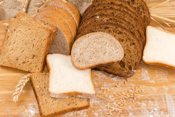 istock Various sliced bread on cutting board with ears, grain, flour 1452926966