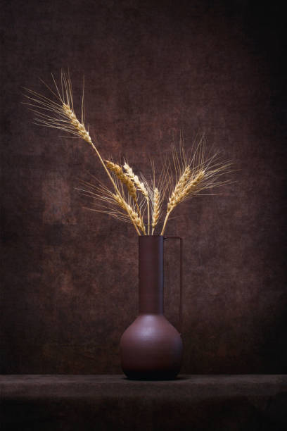 istock Brown vase with wheat ears on a brown background 1452927007