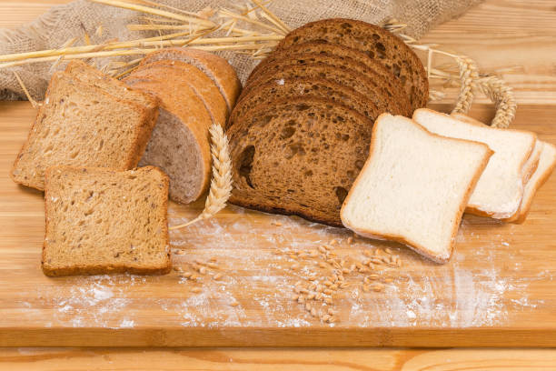 귀, 곡물, 밀가루로 도마에 다양한 얇게 썬 빵 - brown bread 뉴스 사진 이미지