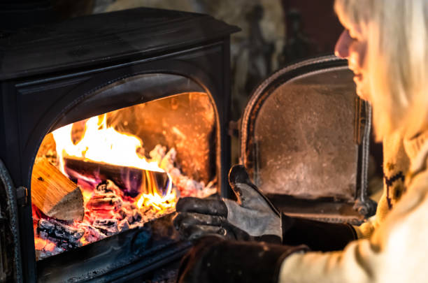 istock Woman putting a log on her stove 1452927270