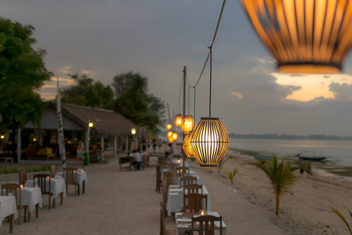 setup for romantic couple dinner next to sea with lights, candle at Gili, Bali, Indonesia