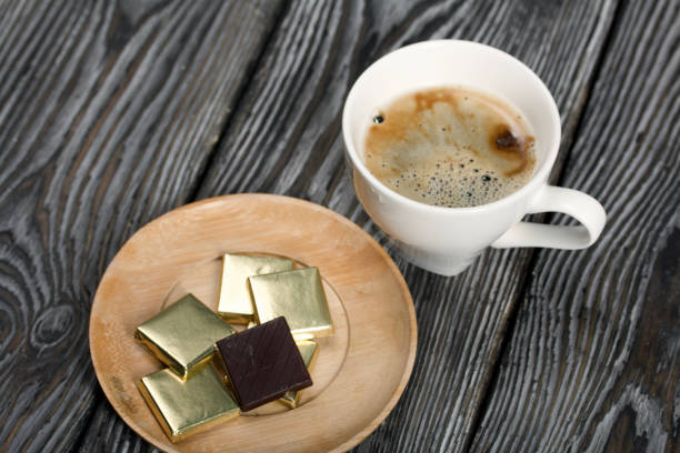 istock A cup of black coffee in a white cup. Chocolate in foil. On pine boards. 1452928526