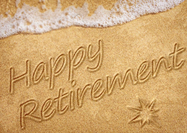 istock Happy Retirement message handwritten on smooth sand beach with gentle wave 1452930034