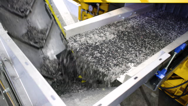 Crumb rubber from an tire moving on the conveyor belt at the recycling factory
