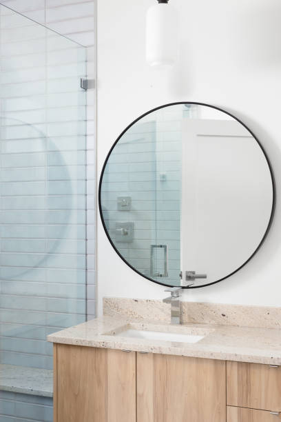 istock A bathroom with a wood cabinet and circular mirror. 1452930832