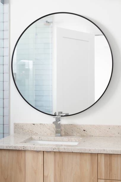 istock A bathroom with a wood cabinet and circular mirror. 1452930840