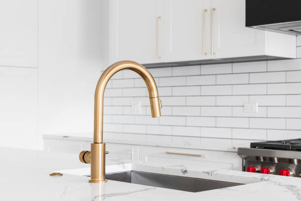 istock A gold kitchen sink detail shot with white cabinets. 1452930859