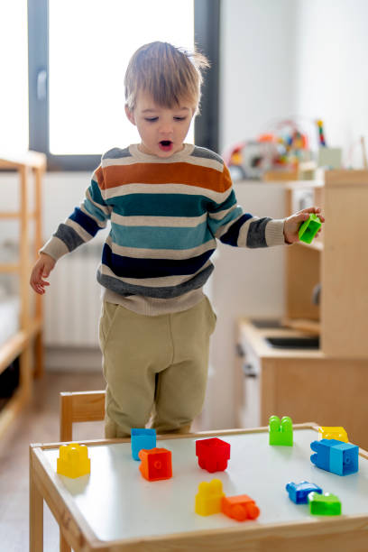 istock Adorable child playing with puzzle pieces at home 1452931785