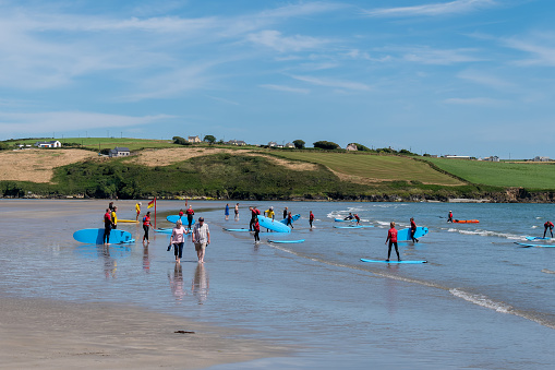 County Cork, Ireland, August 6, 2022. Young people are surfing. A surf school in Ireland. The famous Inchydoney beach.