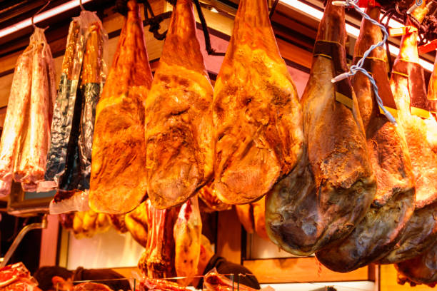 istock Jamon serrano ham legs hanging in a traditional spanish market 1452937378