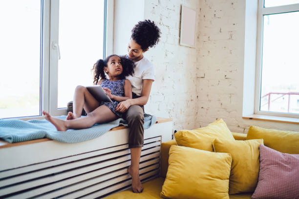 istock Black mother resting on windowsill with kid 1452939207