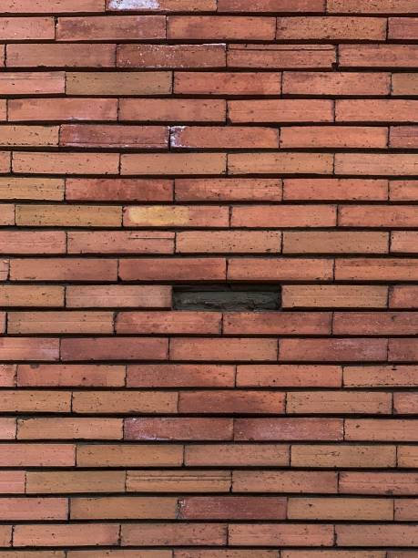 istock Vertical shot of a brick wall with one brick misisng 1452939586