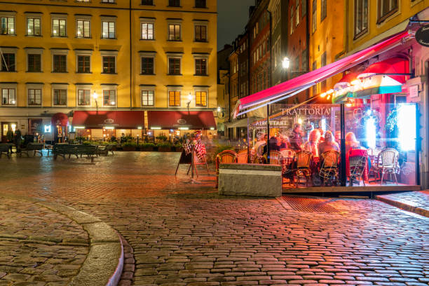 Night scene of people at outdoor restaurant at the historic town square Stortorget in the Old Town in Stockholm. stock photo