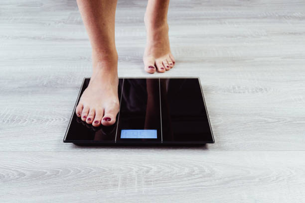 istock Female feet weighing scale 1452943208