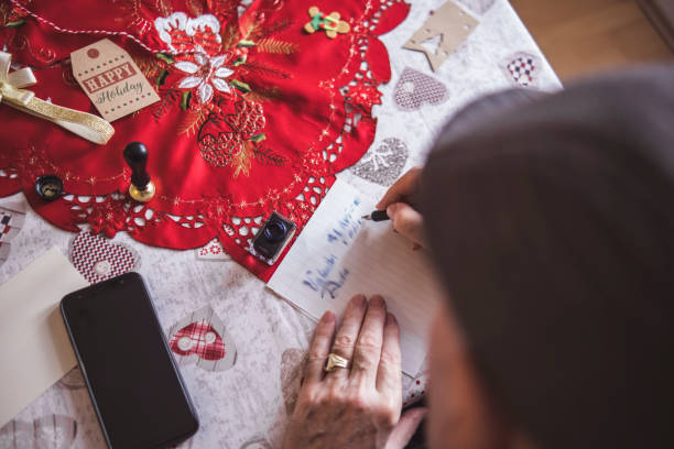 istock Grandfather writing handwritten Christmas invitations 1452943486