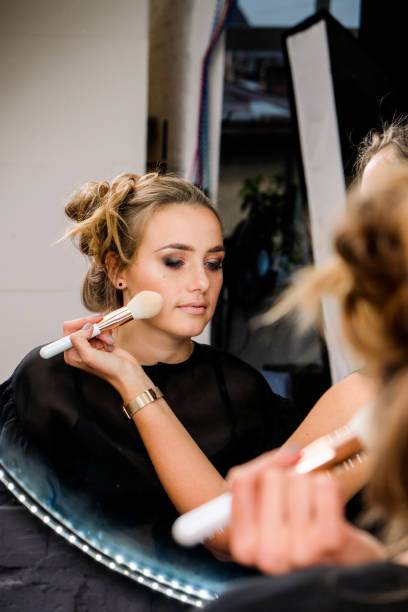 istock Process of applying makeup. Make-up artist working with brush on model face. 1452944175