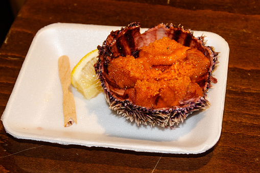 Fresh sea urchin with lemon on wooden table