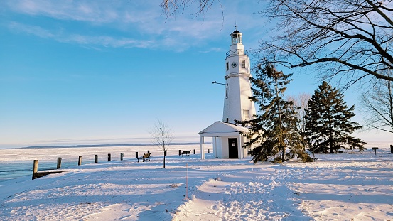 Lighthouse in a winter with frozen lake background