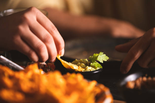 istock woman dipping a nacho in cheese 1452947132