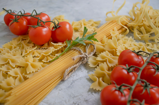 dry pasta, tomato on old background