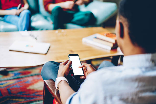 istock Black person surfing smartphone at table on meeting 1452948734