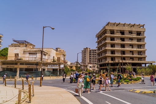 Varosha, Cyprus – April 26, 2022: A tourist crowds near the abandoned buildings in the ghost town beach resort of Varosha, Famagusta