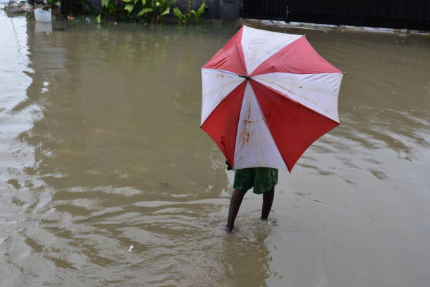 African kid walking on a flooded street stock photo