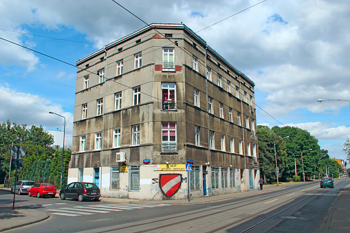 Lodz - Poland. 17 August 2019: 
Architectural ensemble of building. House with unique architecture. Urban view. Triangular four-story house standing over the road
