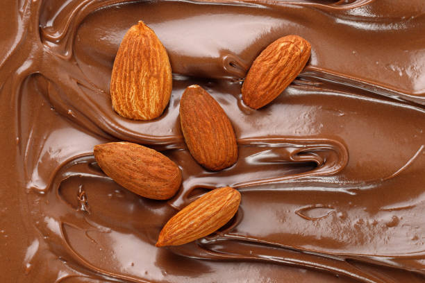 istock Chocolate cream with almond nuts. Sauce, paste, syrup. Background of  Liquid chocolate. Curl. Texture, Close up, top view. 1452952898
