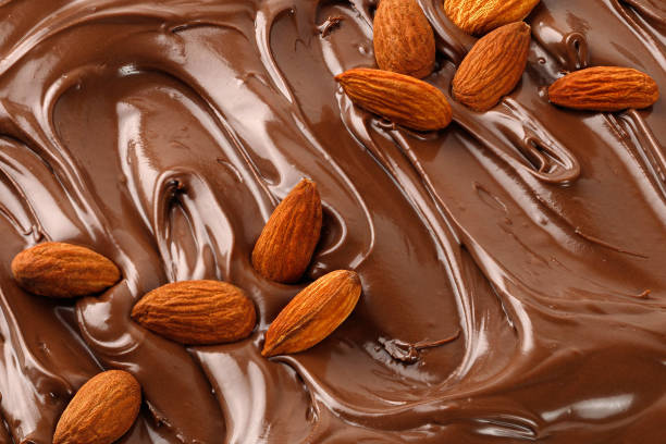 istock Chocolate cream with almond nuts. Sauce, paste, syrup. Background of  Liquid chocolate. Curl. Texture, Close up, top view. 1452953403
