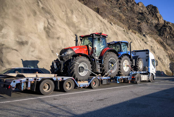 a trailer carrying two large tractors