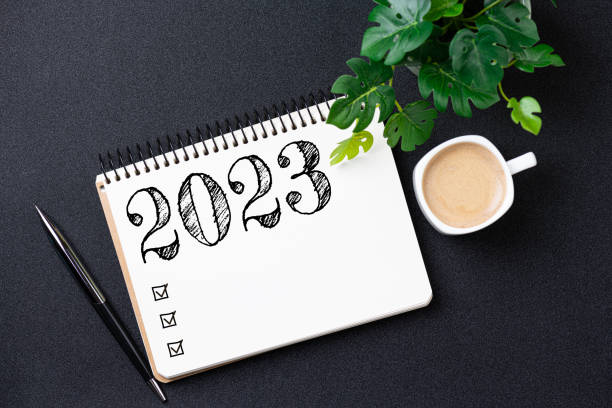 istock New year resolutions 2023 on desk. 2023 resolutions list with notebook, coffee cup on black background. Goals, resolutions, plan, action, checklist concept. New Year 2023 template, copy space 1452956040
