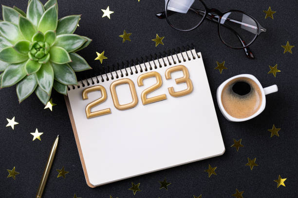istock New year resolutions 2023 on desk. 2023 resolutions list with notebook, coffee cup on black background. Goals, resolutions, plan, action, checklist concept. New Year 2023 template 1452956103
