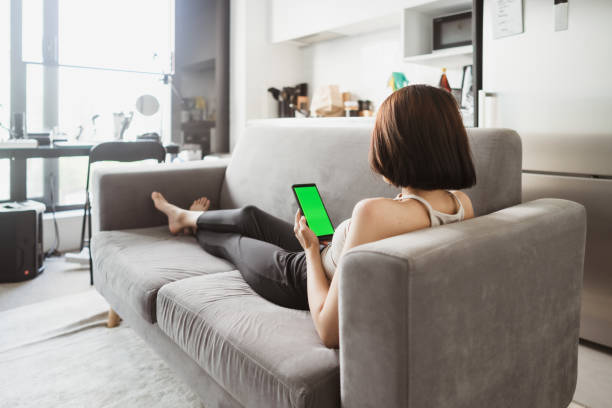 istock Young woman on couch using smart phone. 1452961648
