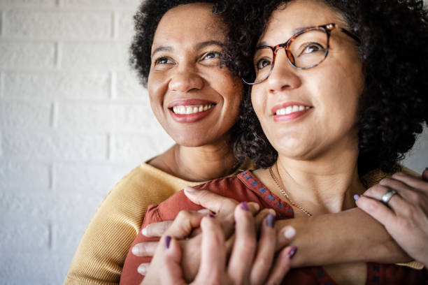 primo piano della coppia lesbica di metà età adulta che abbraccia - homosexual homosexual couple black ethnic foto e immagini stock