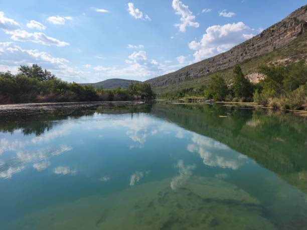 istock High-angle shot of Devils river with trees, rocky mountains, and sky reflected in the water 1452969370