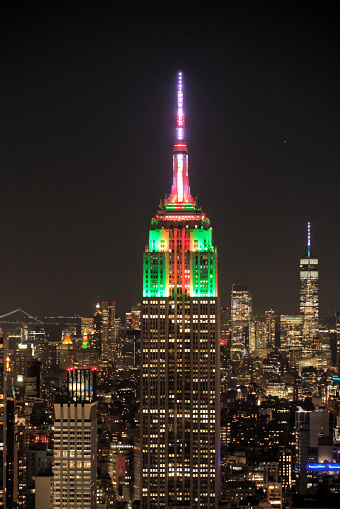 New York, USA-December 24, 2022: The top of the Empire State Building at night on Christmas Eve, lit with stunning colorful lighting.