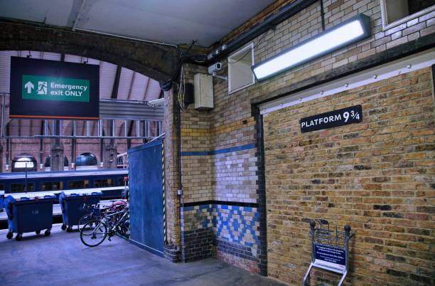 Platform 9 and 3/4 at King's Cross Railway station, with a luggage trolley passing through the wall, as in the Harry Potter stories stock photo