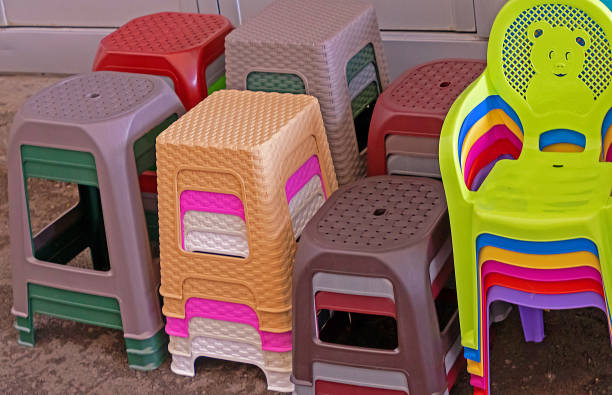 Pile of colorful plastic chairs furniture sold outside on market