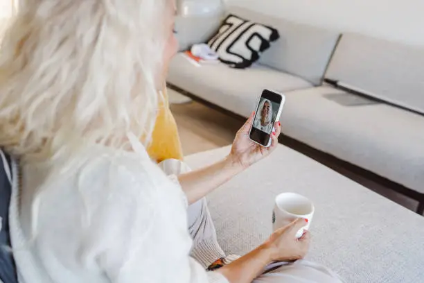 Photo of a mature woman taking a selfie at home in the morning